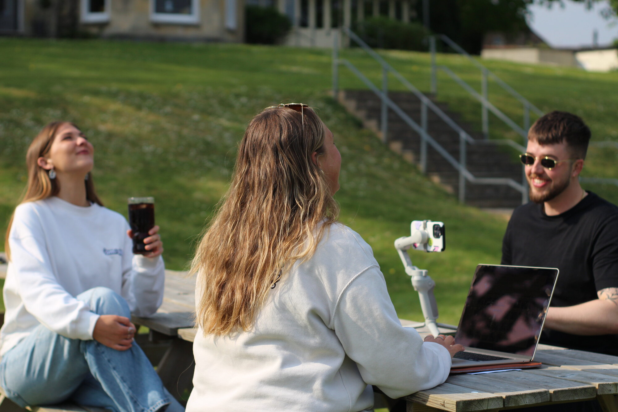 Compelite Pro team filming social content together at a picnic table — culture in action