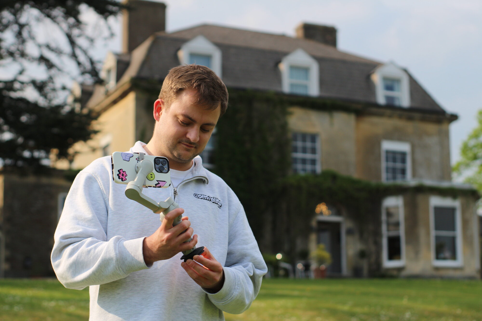 Compelite Pro team member filming branded content with a gimbal in front of a Bristol manor — day in the life