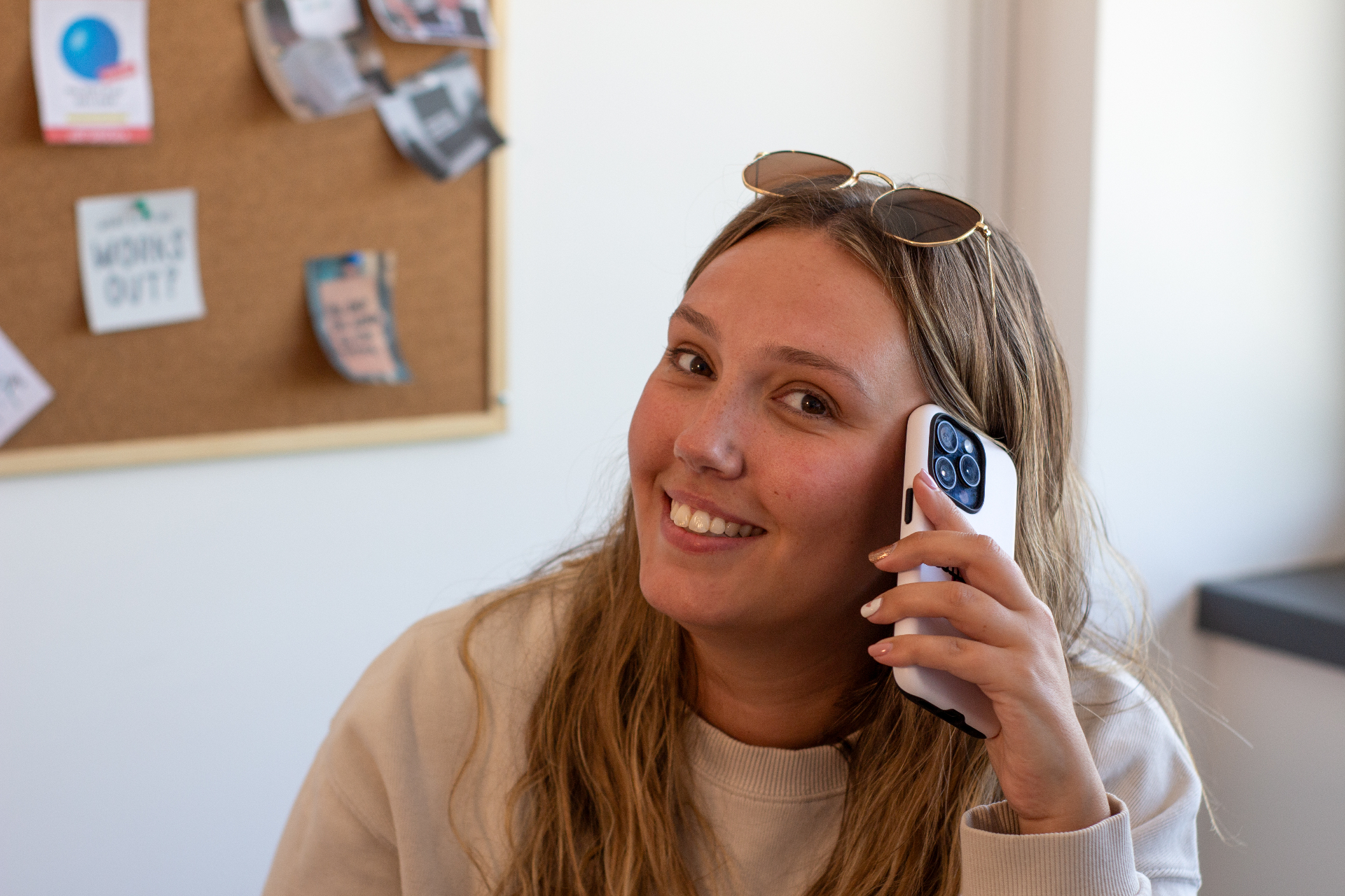 Compelite Pro founder smiling on a phone call in the Bristol studio with a moodboard in the background
