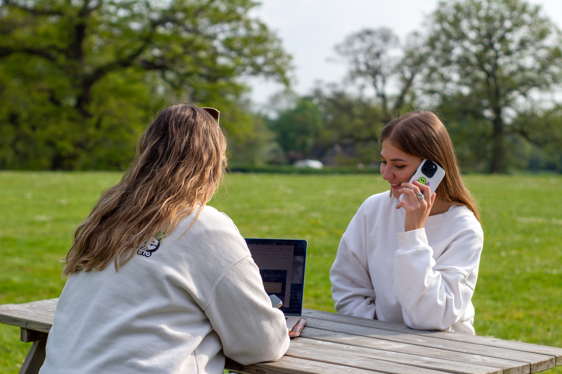 The Compelite Pro team gathered around an outdoor picnic table in branded sweatshirts