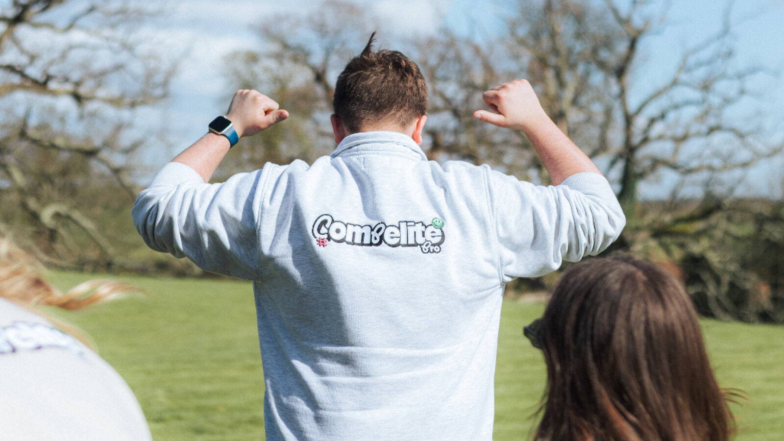 Compelite Pro team member proudly showing the branded sweater logo on his back — transparency and honesty in action