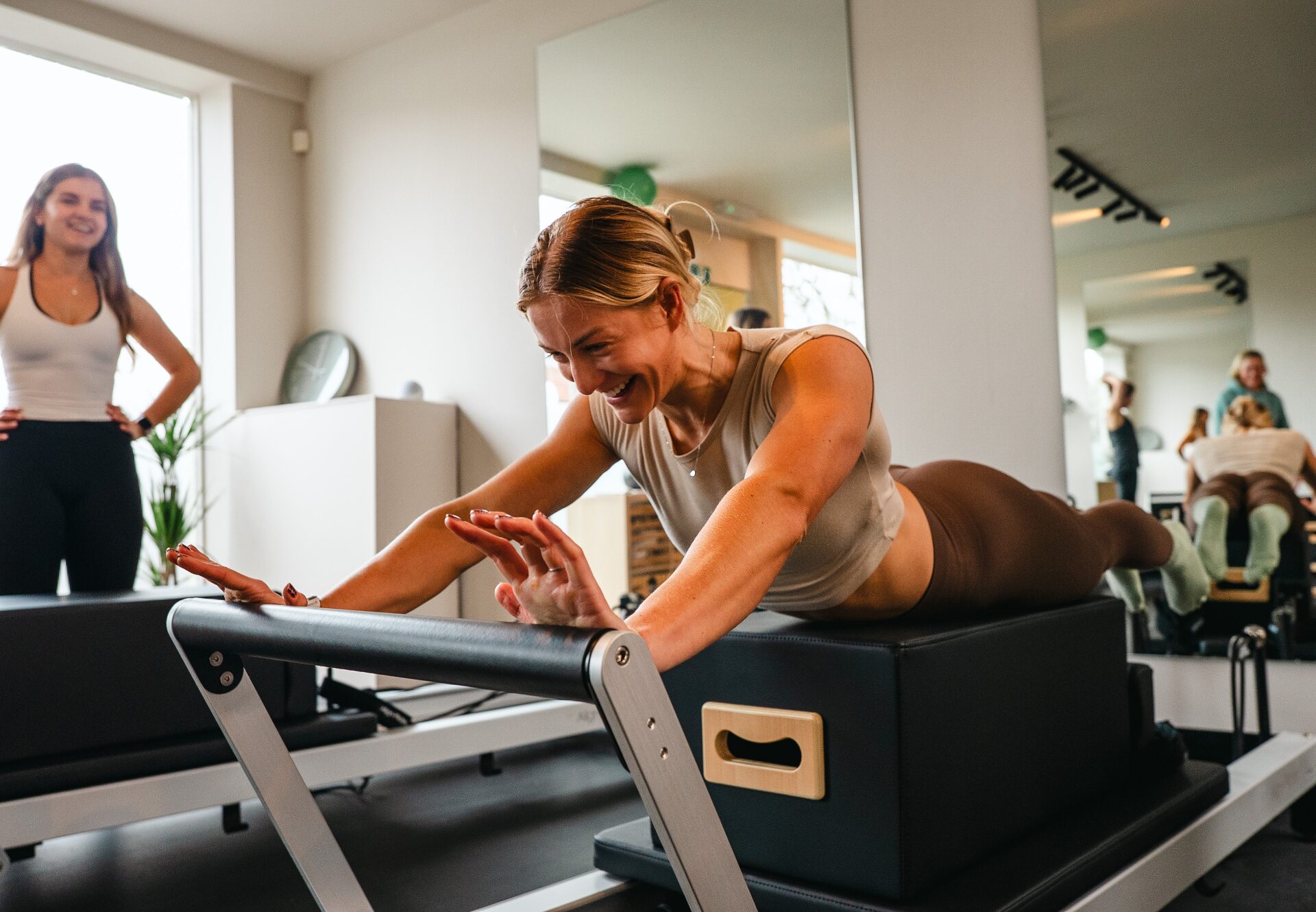 Bristol Pilates client smiling on a reformer during a class