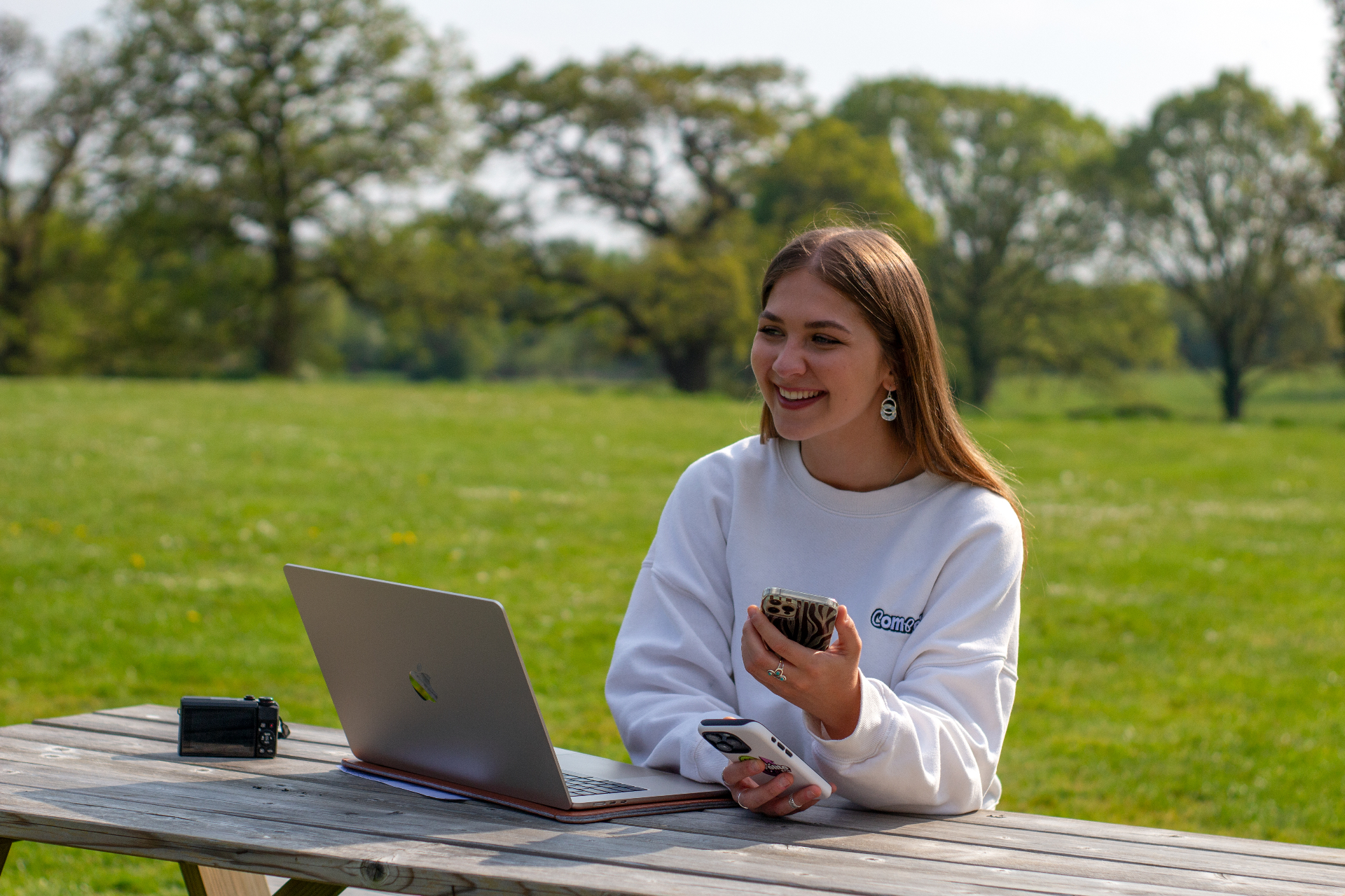 Compelite Pro team member working with a laptop and phone outdoors — partner collaboration